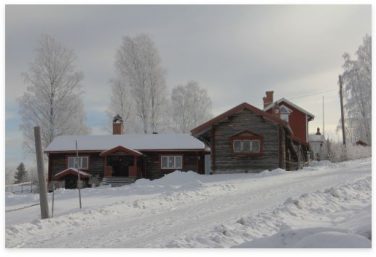Bild på en stuga täckt med snö