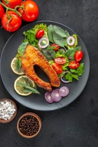 top-view-tasty-cooked-fish-with-fresh-vegetables-dark-table