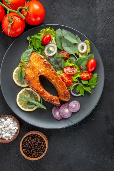 top-view-tasty-cooked-fish-with-fresh-vegetables-dark-table