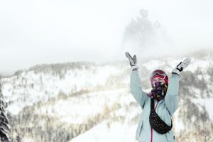 woman-watches-how-snow-falls-down-her-face-while-she-poses-winter-mountain