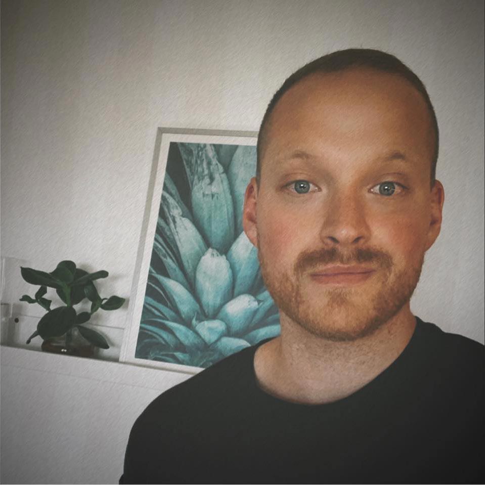 Om Dreamlodge, Porträttbild på Dennis, kort mörkt hårt, leendes