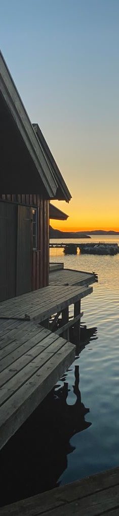 Hus på brygga i solnedgången
