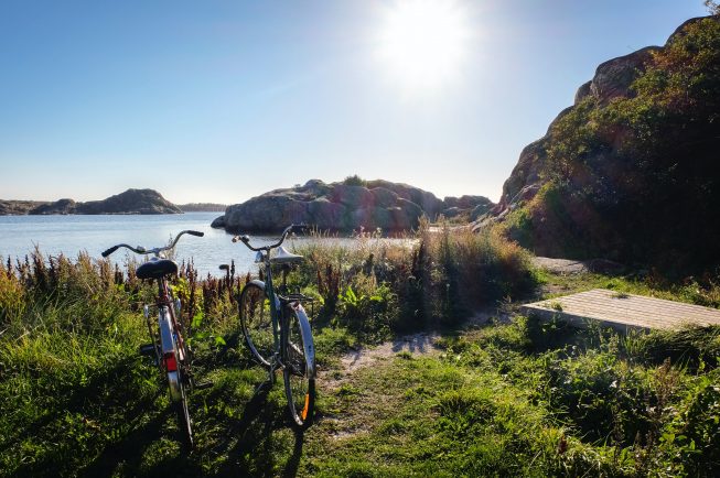 Två cyklar i gräset bredvid vattnet