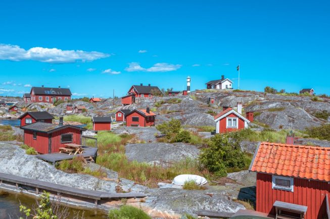 Röda små hus under en blå himmel